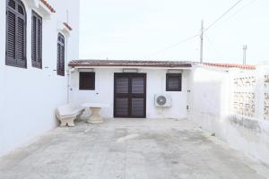 Uma casa branca com um banco à frente. em La Bellavista Mola di Bari em Mola di Bari
