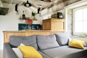 a living room with a gray couch with yellow pillows at Soulié du Tarn in Réquista