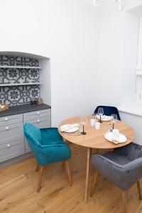 a kitchen with a wooden table and two blue chairs at Lossi 32 Luxury Apartment with Sauna in Tartu