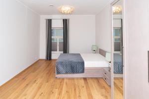 een witte slaapkamer met een bed en een spiegel bij Lossi 32 Luxury Apartment with Sauna in Tartu