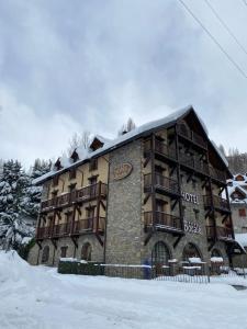 a large building with snow in front of it at Hotel Bocalé in Sallent de Gállego