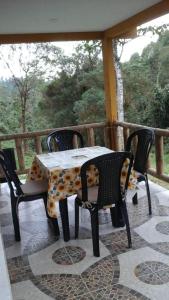 une table et des chaises assises sur une terrasse couverte avec une table et des chaises dans l'établissement Eco-Cabaña Termales Santa Rosa, à Santa Rosa de Cabal