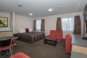 a hotel room with a bed and a table and chairs at Bella Vista Motel Fox Glacier in Fox Glacier