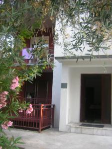 a building with a balcony and pink flowers at Lazar Apartments in Petrovac na Moru