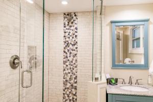 uma casa de banho com uma cabina de duche em vidro e um lavatório. em The Inn on Siesta Key em Siesta Key