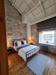 sypialnia z łóżkiem i kamienną ścianą w obiekcie Clarence at Royal William Yard w mieście Plymouth