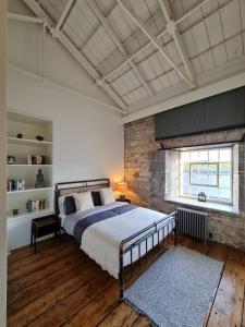 a bedroom with a large bed and a brick wall at Clarence at Royal William Yard in Plymouth