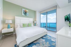a bedroom with a white bed and a large window at Churchill Suites Monte Carlo Miami Beach in Miami Beach +27 photos