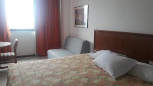 ein Hotelzimmer mit einem Bett und einem Sofa in der Unterkunft Apart Hotel Sol Vitória Marina in Salvador