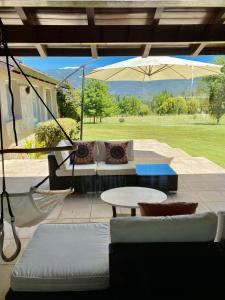 a patio with a couch and a table and an umbrella at La Aguada in El Bolsón