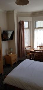 sypialnia z łóżkiem, stołem i telewizorem w obiekcie 6 berth ground floor flat Glen Villa 2 w mieście Great Yarmouth
