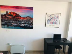 Habitación con escritorio y una foto en la pared. en Beach Suite, city & mountain view en Alicante