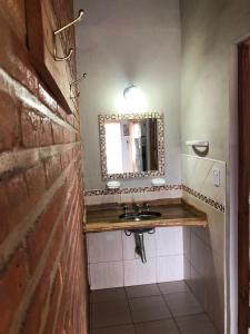 ein Badezimmer mit Waschbecken und Spiegel in der Unterkunft Cabañas La Querencia 2 dormitorios in Villa Cura Brochero