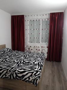 een slaapkamer met een zwart-wit bed en rode gordijnen bij Apartament Elena in Sinaia