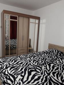 een bed met zebraprint in een slaapkamer met een spiegel bij Apartament Elena in Sinaia +3 foto's