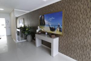 ein Zimmer mit einem Bild eines Bootes an der Wand in der Unterkunft 1024 - Apartamento em Bombinhas para locação de temporada - Praia de Bombas in Bombas