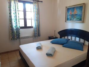 een slaapkamer met een bed met blauwe kussens en een raam bij La Garonnette - 150m de la plage in Sainte-Maxime +40 foto's