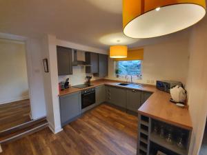 a large kitchen with wooden floors and a large light fixture at Marina House in Whitby