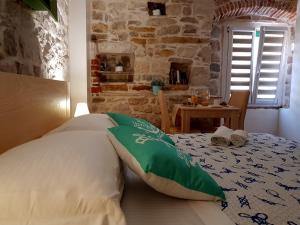 - une chambre avec un lit doté d'oreillers verts et blancs dans l'établissement Villa Nautica Stone House, à Split