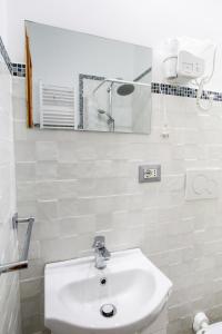 uma casa de banho branca com um lavatório e um espelho em Bed & Breakfast La Rosa em Roma