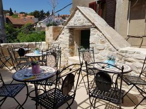 Villa Nautica Stone House في سبليت: فناء في الهواء الطلق مع طاولات وكراسي مع موقد حجري