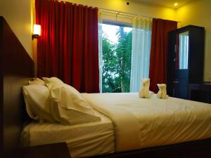a bedroom with a bed with two teddy bears on it at Peakaavu Cottages in Idukki