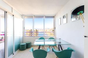 une salle à manger avec une table et des chaises vertes dans l'établissement TROPIC MAR Levante beach apartments, à Benidorm