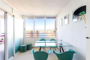 ベニドルムにあるTROPIC MAR Levante beach apartmentsのダイニングルーム(テーブル、緑の椅子付)