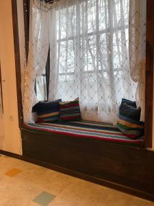 un banco en una ventana con almohadas en The Legends , Art & Forest en Gabrovo