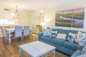 ein Wohnzimmer mit einem blauen Sofa und einem Tisch in der Unterkunft Sea La Vie in Kiawah Island