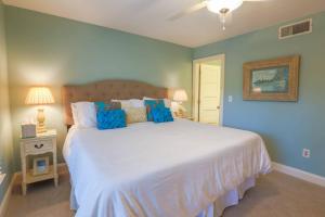 ein Schlafzimmer mit einem großen weißen Bett mit blauen Wänden in der Unterkunft Sea La Vie in Kiawah Island