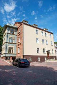 een auto geparkeerd voor een groot gebouw bij Lossi 32 Luxury Apartment with Sauna in Tartu