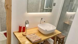 een badkamer met een wastafel en een spiegel op een tafel bij Cristalia,Roof terrace in city center, Garage, Netflix 75inch TV in Funchal