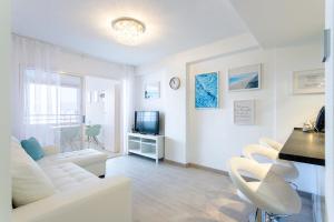 ベニドルムにあるTROPIC MAR Levante beach apartmentsの白いリビングルーム(白いソファ、テレビ付)