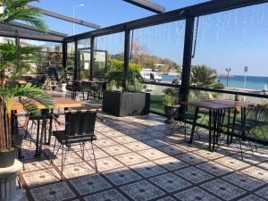 a patio with tables and chairs and a view of the ocean at 8 Rooms Hotel in Gelibolu