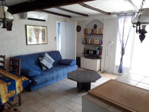 - un salon avec un canapé bleu et une table dans l'établissement Les Amandiers - 5 km de la plage, à Sainte-Maxime