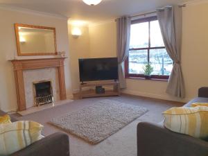 uma sala de estar com televisão e lareira em Marina House em Whitby