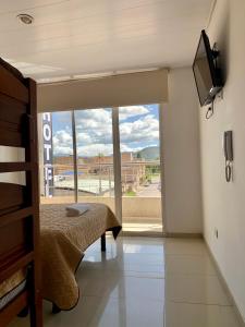 Hotel Universal في دويتاما: غرفة نوم بها سرير ونافذة كبيرة