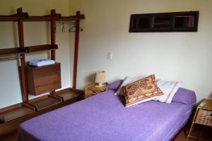 a bedroom with a purple bed and a fan at Kamay Apart Cafayate in Cafayate