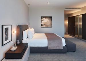 a hotel room with a bed and a desk at Eos by SkyCity in Adelaide
