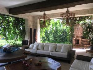 - un salon avec un canapé blanc et une grande fenêtre dans l'établissement Casa Tropical con Hermosos Atardeceres Caribeños, à Santiago de los Caballeros