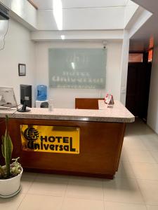 un escritorio de oficina con un cartel de emergencia del hotel en Hotel Universal, en Duitama