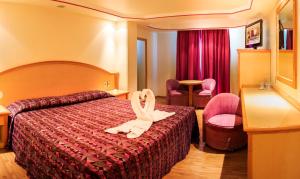 a hotel room with a bed with a towel on it at Hotel Revolución in Mexico City