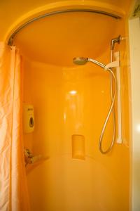 a shower in a bathroom with a yellow wall at Première Classe Clermont Ferrand Nord in Clermont-Ferrand