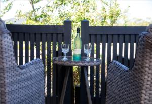 a bottle of wine on a table with two glasses at Bellarine getaway close to beach in Curlewis