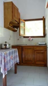 a kitchen with wooden cabinets and a table and a window at Villa Alexandra in Roda