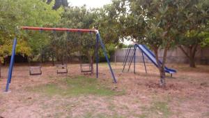 an empty playground with two swings in a park at Villa Alexandra in Roda +16 photos