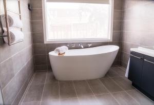 bagno con vasca bianca e finestra di Bellarine getaway close to beach a Curlewis