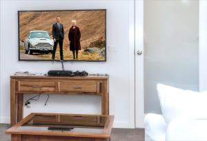 uma sala de estar com uma televisão na parede com um carro em Bellarine getaway close to beach em Curlewis