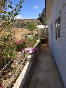 Una pasarela junto a una casa con flores al lado en Hostal los Almendros de Canela en Canela Baja